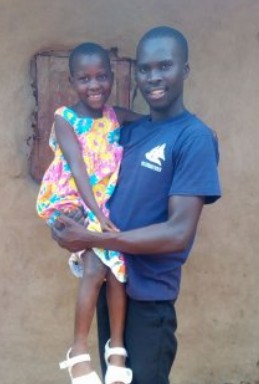 Daniel Mwebaza holding Mariam, one of our orphan girls